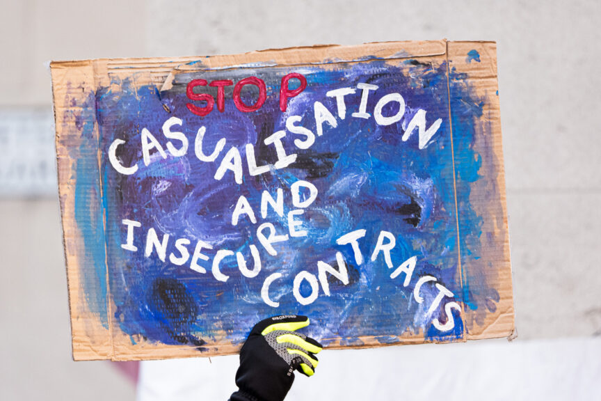 A banner is held aloft, it is blue with white text, "casualisation and insecure contracts"