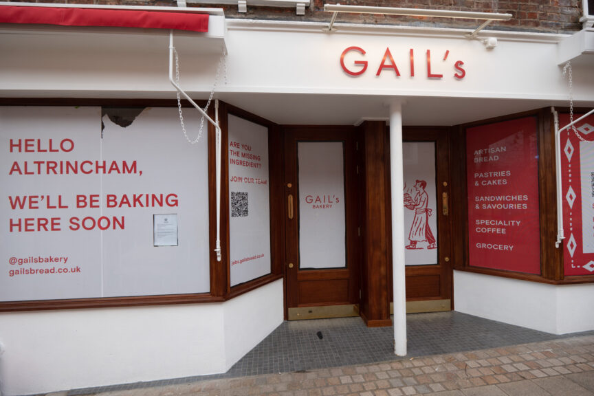 Red-and-white shopfront for Gail's Bakery, prior to opening. The windows are covered from the inside by red-and-white displays to disguise the shop fit-out going on inside.
