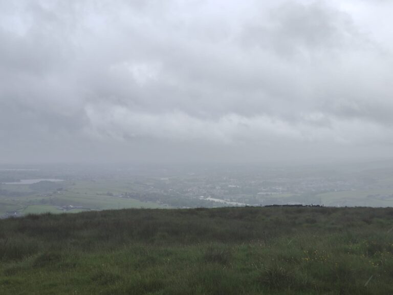 Looking towards Rochdale from the moors on a cloudy day, some landscape features are visible, but not clearly.